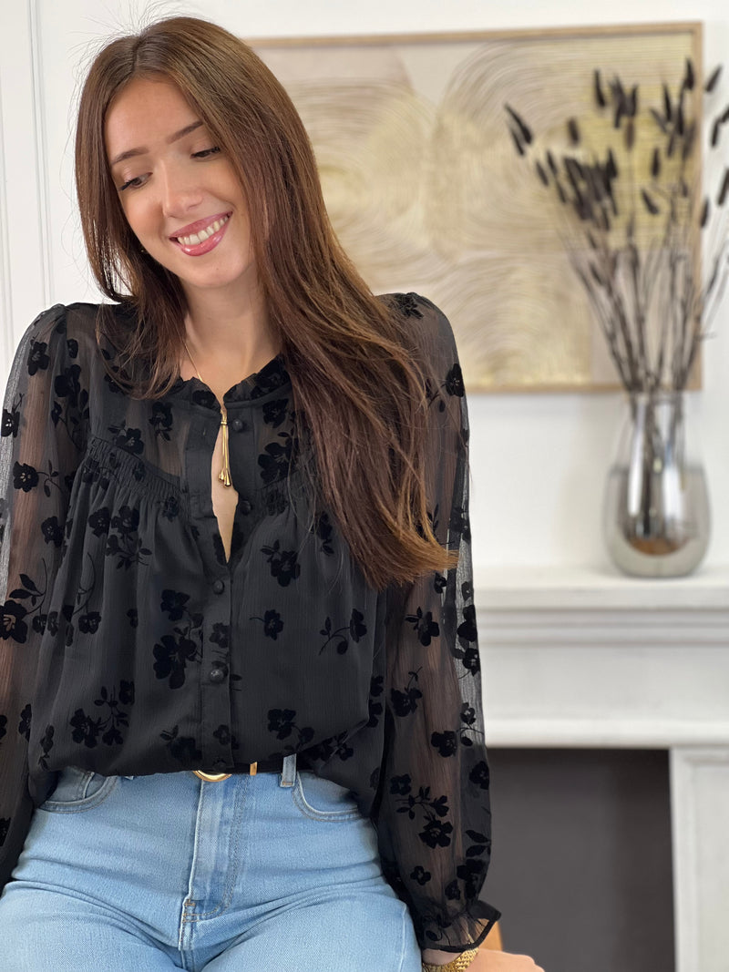 Cette chemise noire à motifs floraux Elenora allie élégance et délicatesse. Ses manches longues et son col rond apportent un charme classique, rehaussé par des volants subtils au col et aux manches.