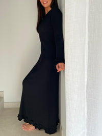 La robe longue noir Esther est un mariage parfait de chic et de confort. Avec ses manches longues et son col rond, elle assure une élégance intemporelle. Mais le dos nu avec lacets croisés et les volants aux manches et au bas de la robe ajoutent une touche ludique et originale. Soyez prête à faire tourner les têtes avec cette robe unique !