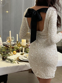 Sublime et raffinée, cette robe beige à sequins dévoile un dos nu élégant rehaussé d’un lien noir à nouer. Son col V à l’arrière et sa coupe fluide apportent une touche glamour et féminine, parfaite pour briller en soirée.