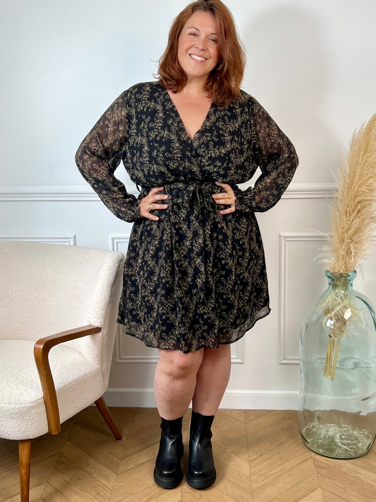 La robe courte Timy offre confort et élégance avec ses manches longues, son col cache-cœur et sa ceinture amovible. Ses motifs floraux en noir et beige donnent une touche élégante et féminine à cette pièce facile à porter au quotidien ou pour des occasions spéciales.