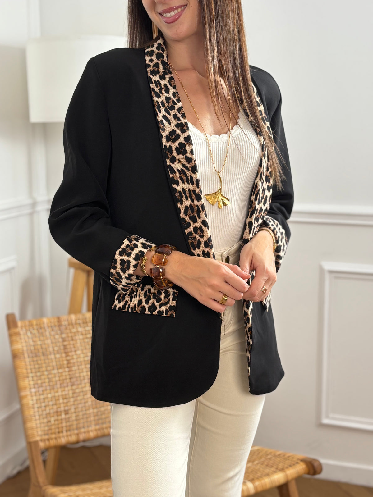 Ce blazer noir, nommé Axella, allie élégance et originalité. Ses manches longues et ses deux poches factices sur le devant offrent une silhouette structurée, tandis que le détail léopard qui court le long des poches et des revers de manches apporte une touche audacieuse et moderne.