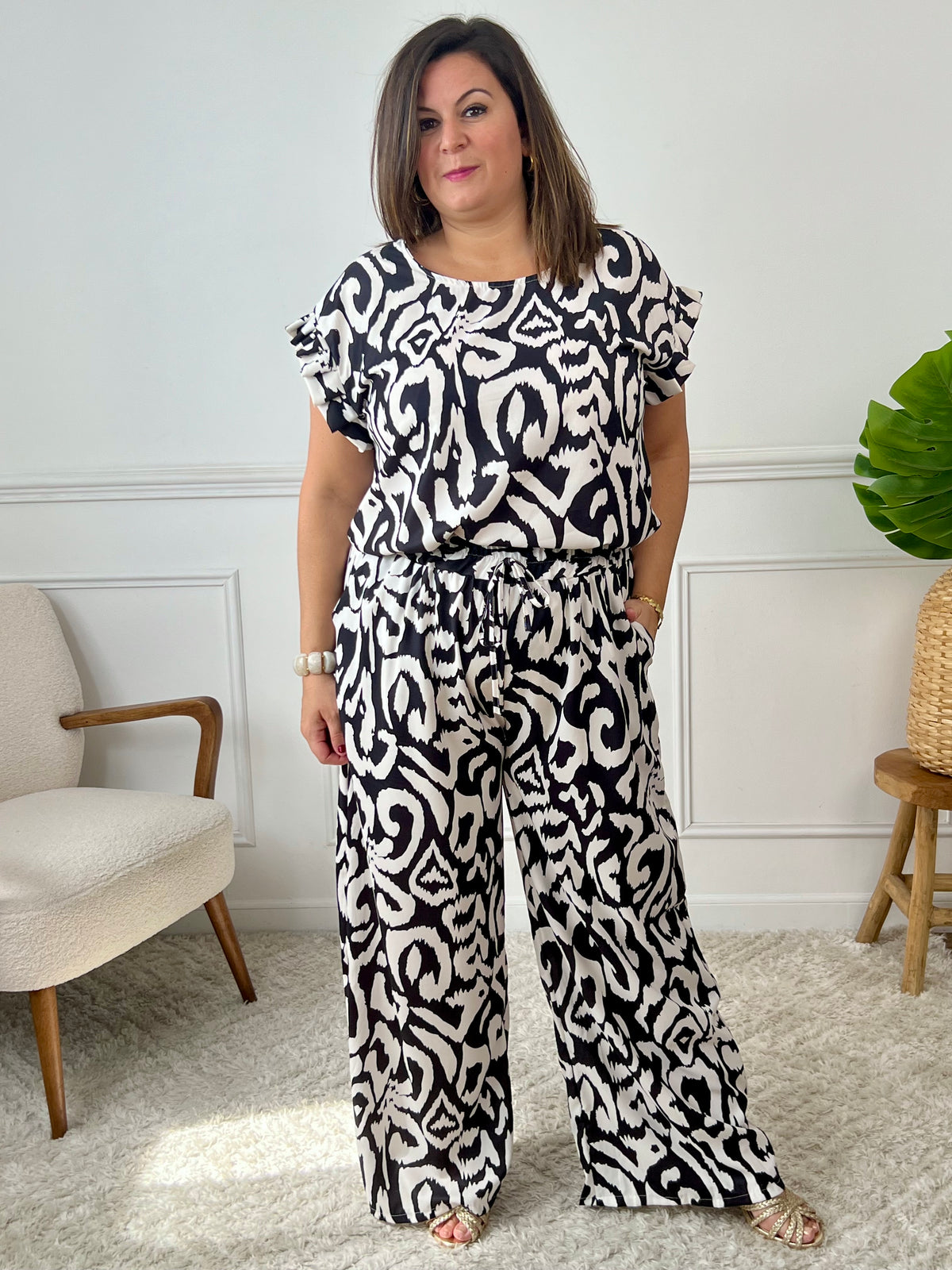 Léger et éclatant, ce top fluide noir et écru sans manches séduit par ses jolis volants aux épaules. Une pièce pleine de fraîcheur et de féminité, parfaite pour égayer vos looks avec une touche raffinée.
