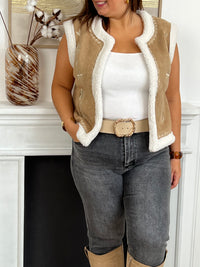 Cette veste sans manches camel Maelia combine douceur et style avec sa moumoute chaleureuse et son col rond confortable. Les motifs floraux apportent une touche féminine et délicate, idéale pour rehausser vos tenues tout en restant confortable.