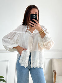 Cette blouse écrue Auriola apporte une touche de sophistication à votre garde-robe avec son élégante broderie et son col rond. Les manches longues et les poignets élastiques offrent un confort incomparable, tandis que les boutons sur le devant ajoutent une touche de style.