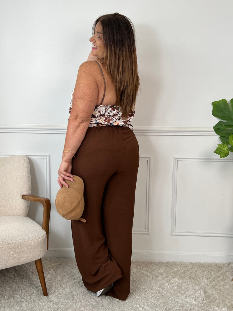 Ce pantalon marron grande taille Karoline est un essentiel pour toutes les femmes. Très confortable avec son élastique au dos et ses poches latérales à l'avant, il ajoute une touche de style avec sa ceinture amovible à motifs assortie au haut Alena.
