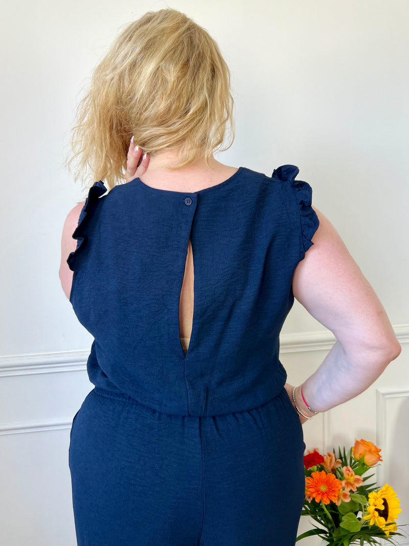 Cette combinaison longue bleue Curve : Liona, une pièce incontournable pour les femmes de grande taille. Avec son col V flatteur, sa taille élastique et son dos nu élégant, elle est à la fois pratique et chic. Ses poches latérales et volants aux épaules ajoutent une touche de style. Disponible en bleu marine et noire