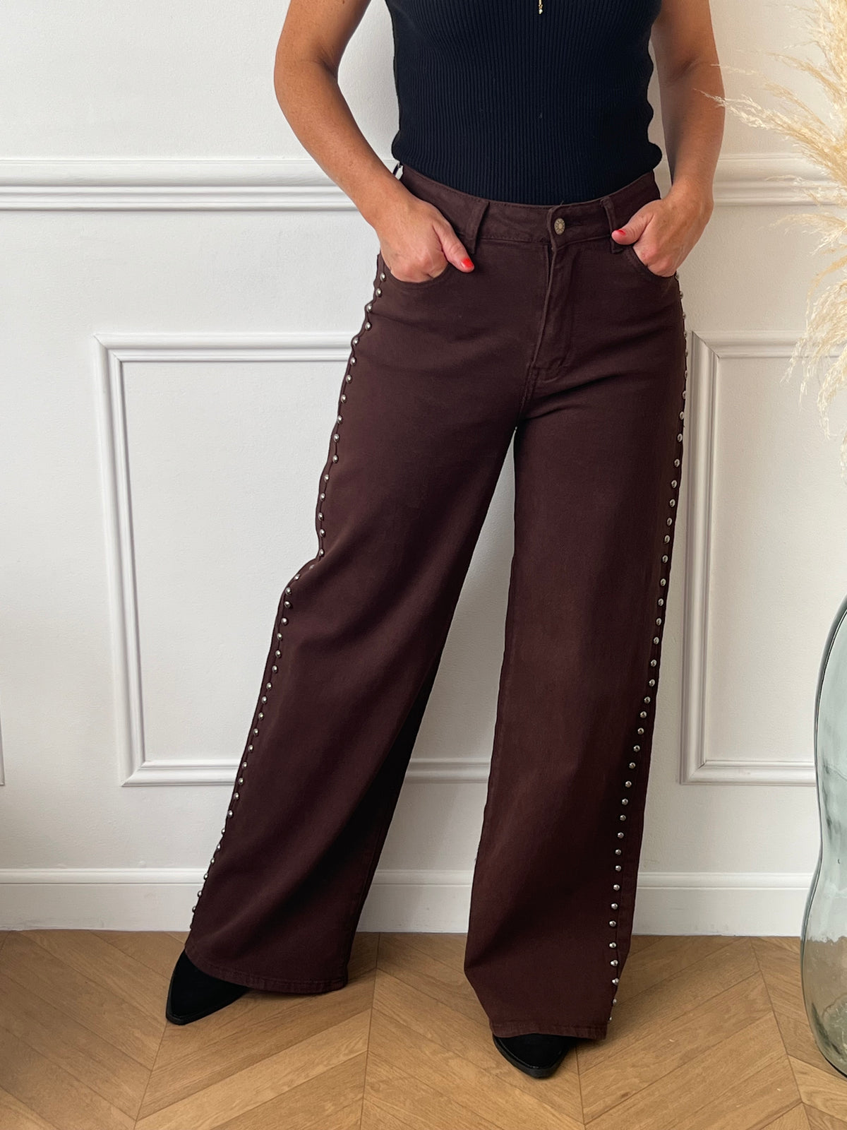 Découvrez notre jean marron coupe Studs Wide Leg, un modèle tendance avec des détails de clous élégants sur les côtés. Ce jean allie confort et style grâce à ses 2 poches avant, 2 poches arrière et ses passants pour ceinture. Sa coupe moderne et sa couleur marron intemporelle en font une pièce unique à intégrer à votre dressing.