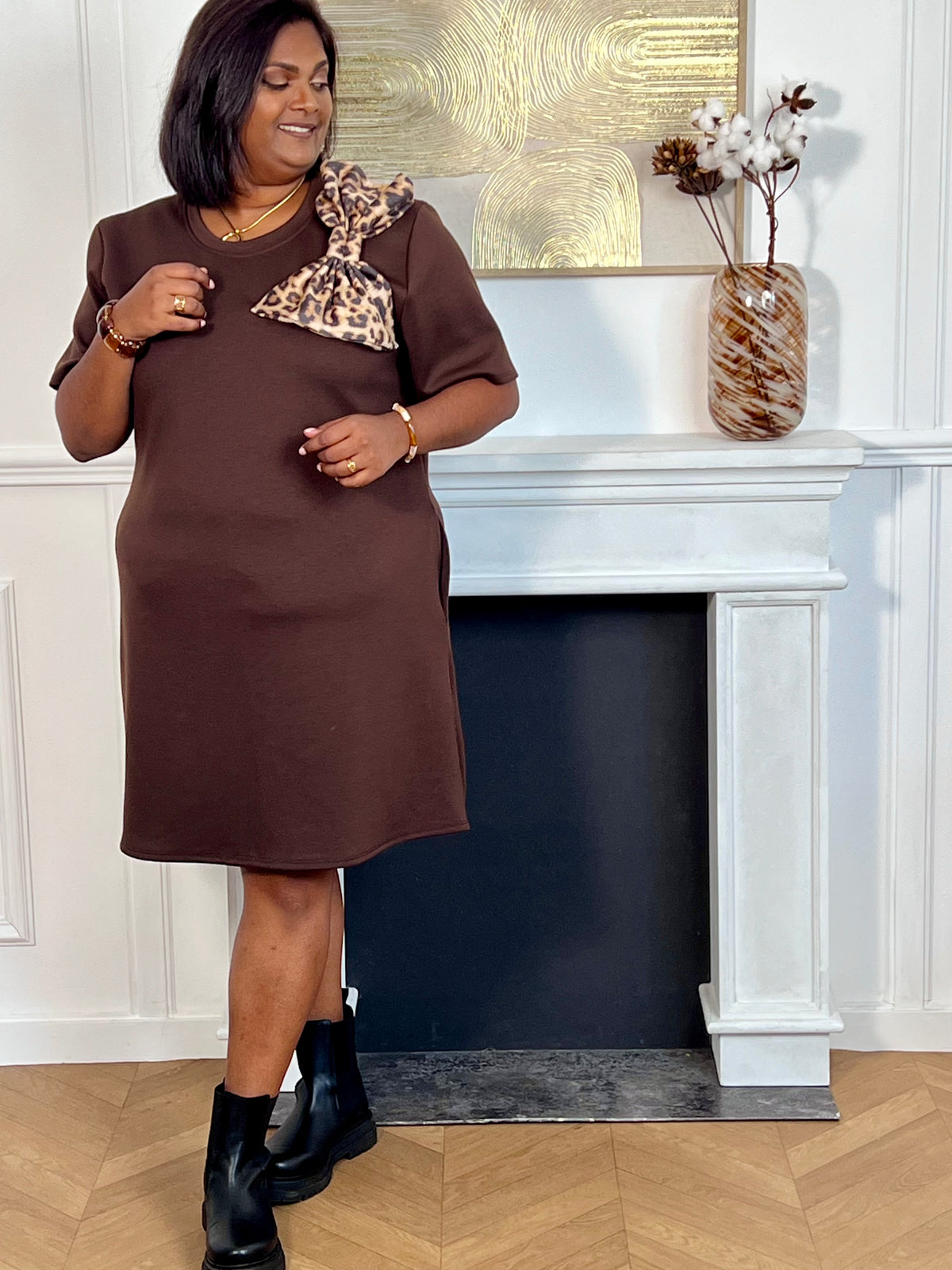 Adoptez un style chic avec cette robe courte marron grande taille à manches courtes et col rond. Son nœud motif léopard sur le devant apporte une touche élégante et tendance. Confectionnée dans une matière épaisse et confortable, elle est disponible en noir, marron et beige.
