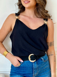 Ce top noir au design épuré séduit par ses bretelles ornées de délicats détails dorés. À la fois sobre et raffiné, il apporte une touche d’élégance à vos looks, de jour comme de nuit.