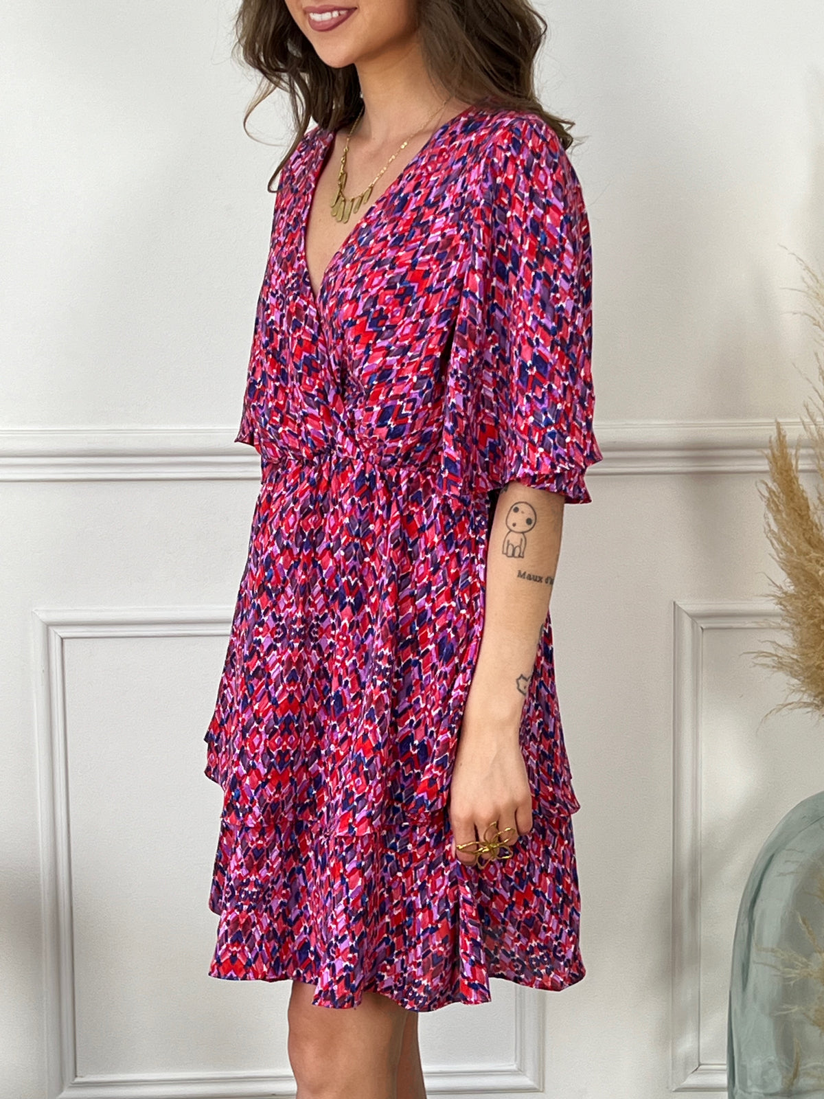 Ajoutez une touche de couleur et de fantaisie à votre garde-robe avec notre robe courte Alisia. Les motifs uniques et vibrants en rose et violet apportent une touche de gaieté à votre tenue, tandis que le col cache-coeur flatteur et les manches courtes vous assurent une silhouette élégante. Faites-vous remarquer avec style et confort avec notre robe Alisia.