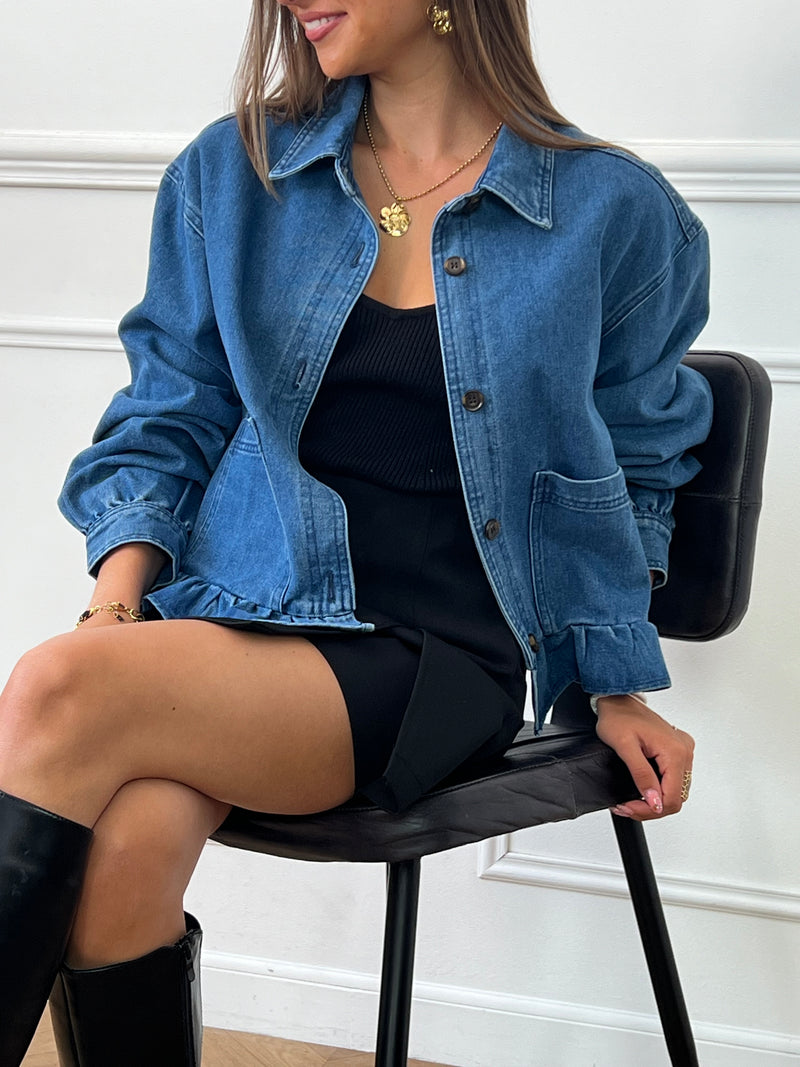 Avec ses manches longues bouffantes et ses volants sur le bas, cette veste courte en jean bleue est à la fois féminine et tendance. Les boutons sur la longueur et aux poignets ainsi que les 2 poches latérales ajoutent une touche pratique à ce vêtement indispensable de tout look décontracté.