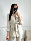Optez pour un look chic et élégant avec notre blazer beige Salome pour femme ! Avec sa ceinture amovible et ses épaulettes, il mettra en valeur votre silhouette tout en vous offrant une allure sophistiquée. Doté d'un bouton et de 2 poches factices à l'avant, il est aussi pratique qu'élégant. Doublé pour un confort optimal, il apportera une touche tendance à votre tenue. À associer avec le pantalon Salome pour un look complet.