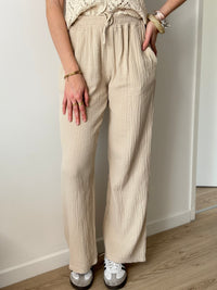 Adoptez le pantalon beige Jolina en gaze de coton. Sa coupe large et sa taille élastique offrent un confort optimal.