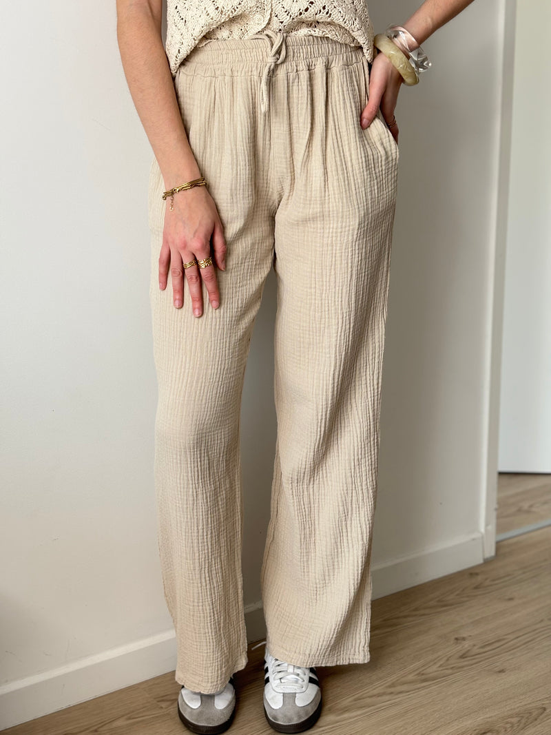 Adoptez le pantalon beige Jolina en gaze de coton. Sa coupe large et sa taille élastique offrent un confort optimal.