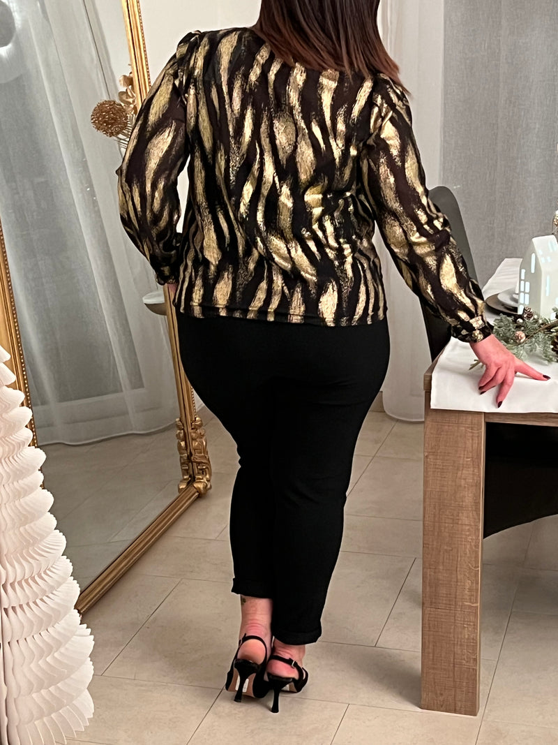 Découvrez la chemise Laina, une pièce festive qui allie élégance et confort. Avec son col V plongeant et ses manches longues ornées de volants délicats, elle crée une silhouette flatteuse et sophistiquée.