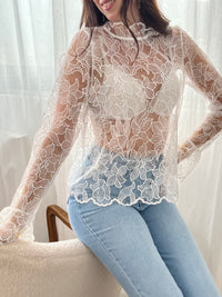 Cette blouse écrue Evelina allie délicatesse et élégance. Confectionnée en broderie ajourée, elle offre une touche de légèreté et de fraîcheur. Son col rond orné de volants apporte une note féminine raffinée, tandis que les deux boutons sur le devant facilitent l’enfilage.