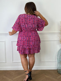 Découvrez notre robe Curve Alisia ! En plus de son col cache-coeur flatteur, ses manches courtes et sa taille élastique, elle offre une explosion de couleurs avec des motifs rose, violet, rouge et écru. Les volants sur le bas ajoutent une touche originale à cette robe doublée, idéale pour toutes les occasions !