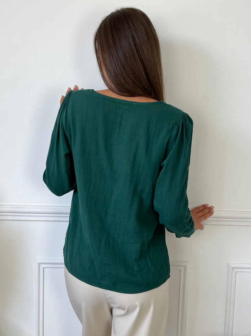 Une chemise à manches longues en gaz de coton vert sapin, parfaite pour allier confort et style. Son col V festonné ajoute une touche délicate et féminine, tandis que la texture légère et douce du tissu assure une sensation agréable sur la peau. Idéale pour créer une tenue élégante tout en restant décontractée, cette chemise se distingue par son charme naturel et son allure intemporelle.