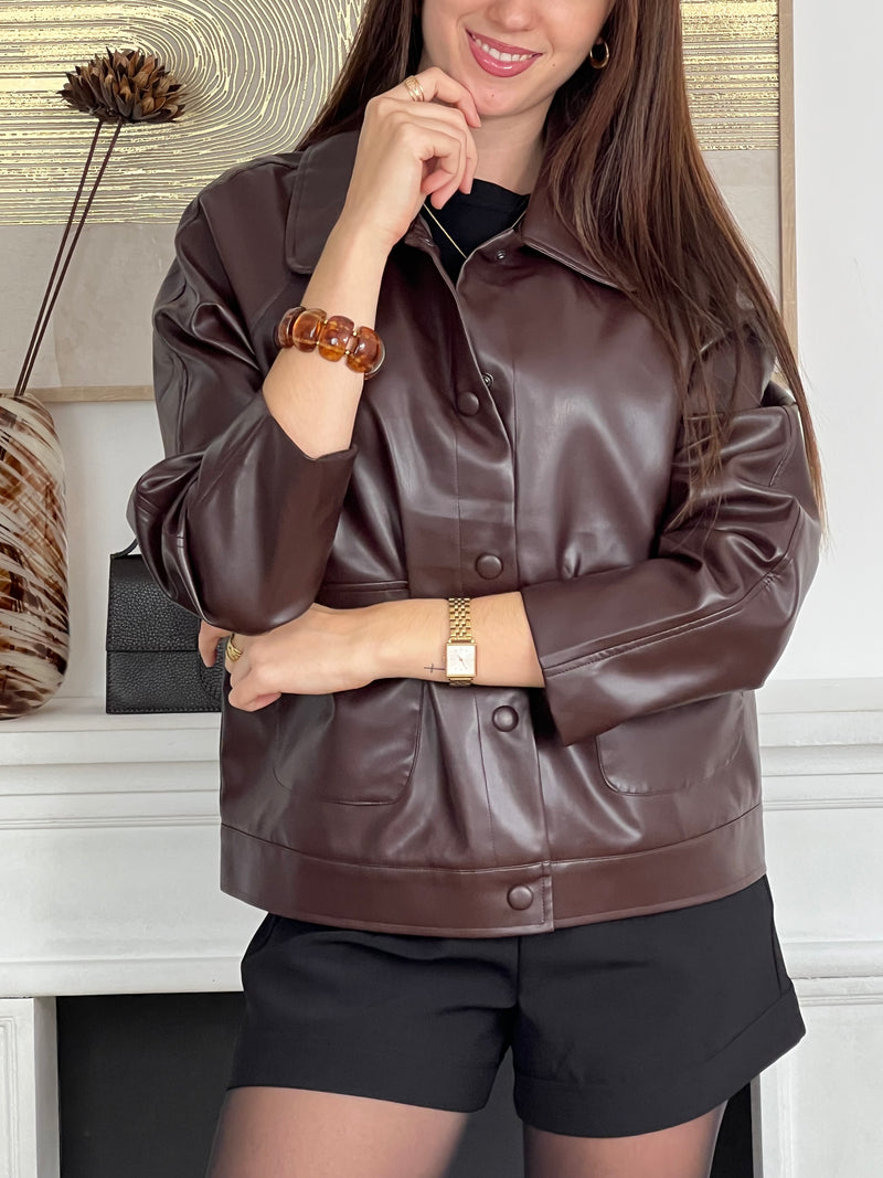Élégante et originale, cette veste marron aux légers reflets bordeaux séduit par son jeu de nuances raffinées. Dotée de deux poches pratiques à l’avant, elle allie style et fonctionnalité pour sublimer vos looks du quotidien.