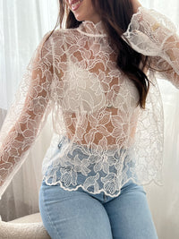 Cette blouse écrue Evelina allie délicatesse et élégance. Confectionnée en broderie ajourée, elle offre une touche de légèreté et de fraîcheur. Son col rond orné de volants apporte une note féminine raffinée, tandis que les deux boutons sur le devant facilitent l’enfilage.