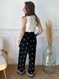 Découvrez notre pantalon en lin noir, rehaussé de motifs écru élégants. Parfait pour les journées ensoleillées et les soirées estivales grâce à sa couleur, il allie confort et style.