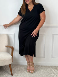 Cette robe longue noire grande taille Clothilde allie élégance et confort. Ses manches courtes avec revers et son col en V apportent une touche raffinée, tandis que la coupe ample assure une aisance parfaite.