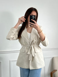 Optez pour un look chic et élégant avec notre blazer beige Salome pour femme ! Avec sa ceinture amovible et ses épaulettes, il mettra en valeur votre silhouette tout en vous offrant une allure sophistiquée. Doté d'un bouton et de 2 poches factices à l'avant, il est aussi pratique qu'élégant. Doublé pour un confort optimal, il apportera une touche tendance à votre tenue. À associer avec le pantalon Salome pour un look complet.