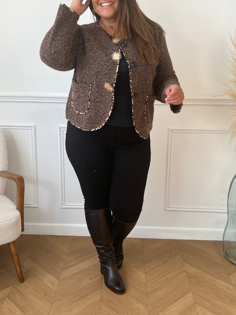 Chic et audacieuse, cette veste marron se démarque par son pourtour souligné d’une fine bande léopard, subtile touche de caractère. Pratique et élégante, elle est dotée de deux poches à l’avant et s’agrémente d’épingles amovibles dorées, offrant la possibilité de personnaliser votre look au gré de vos envies.