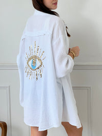 Optez pour la chemise Flore en gaze de coton écrue, avec ses boutons sur la longueur et aux manches, son col chemise et son motif en sequin à l'arrière. Une touche d'originalité pour un look décontracté et tendance. Parfait pour toutes les occasions !