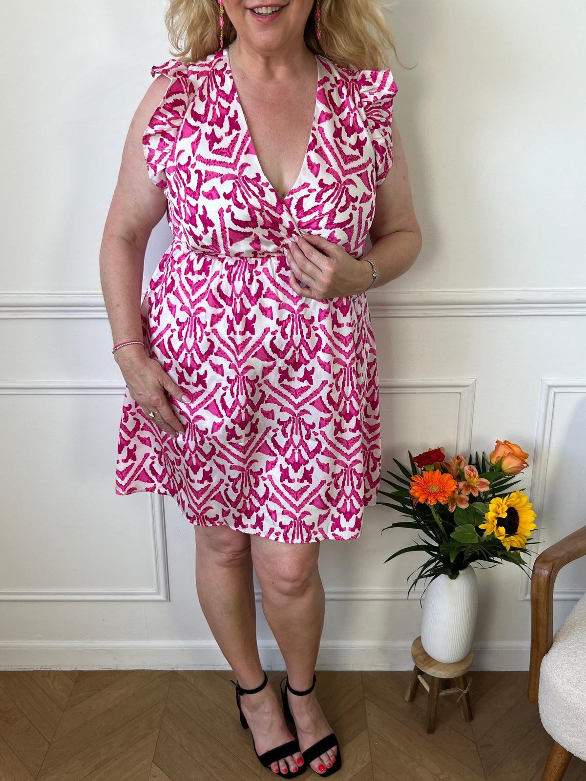 Découvrez notre robe short rose et écrue : Kenzi avec des volants aux épaules et un col cache coeur. Avec un lien à nouer au dos, élastique à la taille, et motifs assortis, cette robe peut être portée pour toutes occasions. Féminine et confortable, elle vous mettra en valeur en toutes circonstances!