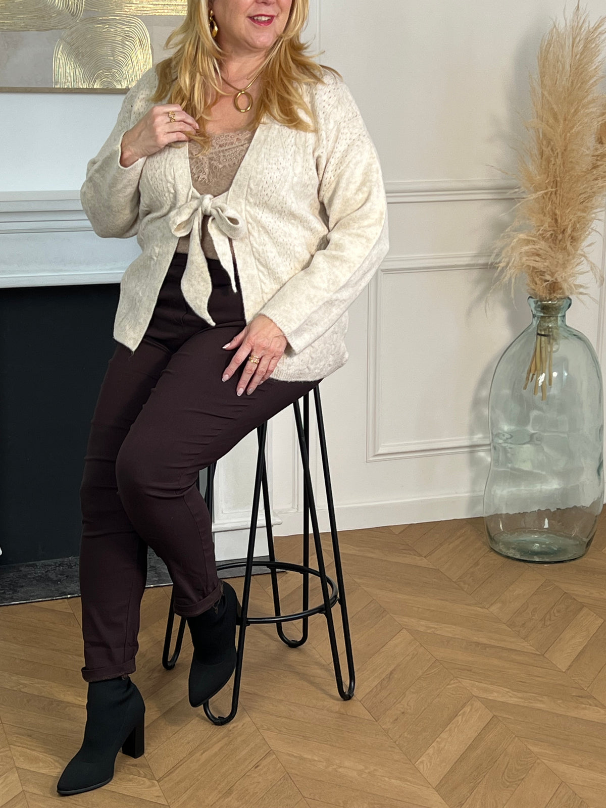 Chic et confortable, ce gilet beige séduit par ses jolis motifs en relief et ses liens de serrage à l’avant. Une pièce élégante et féminine, parfaite pour un look à la fois cosy et raffiné.