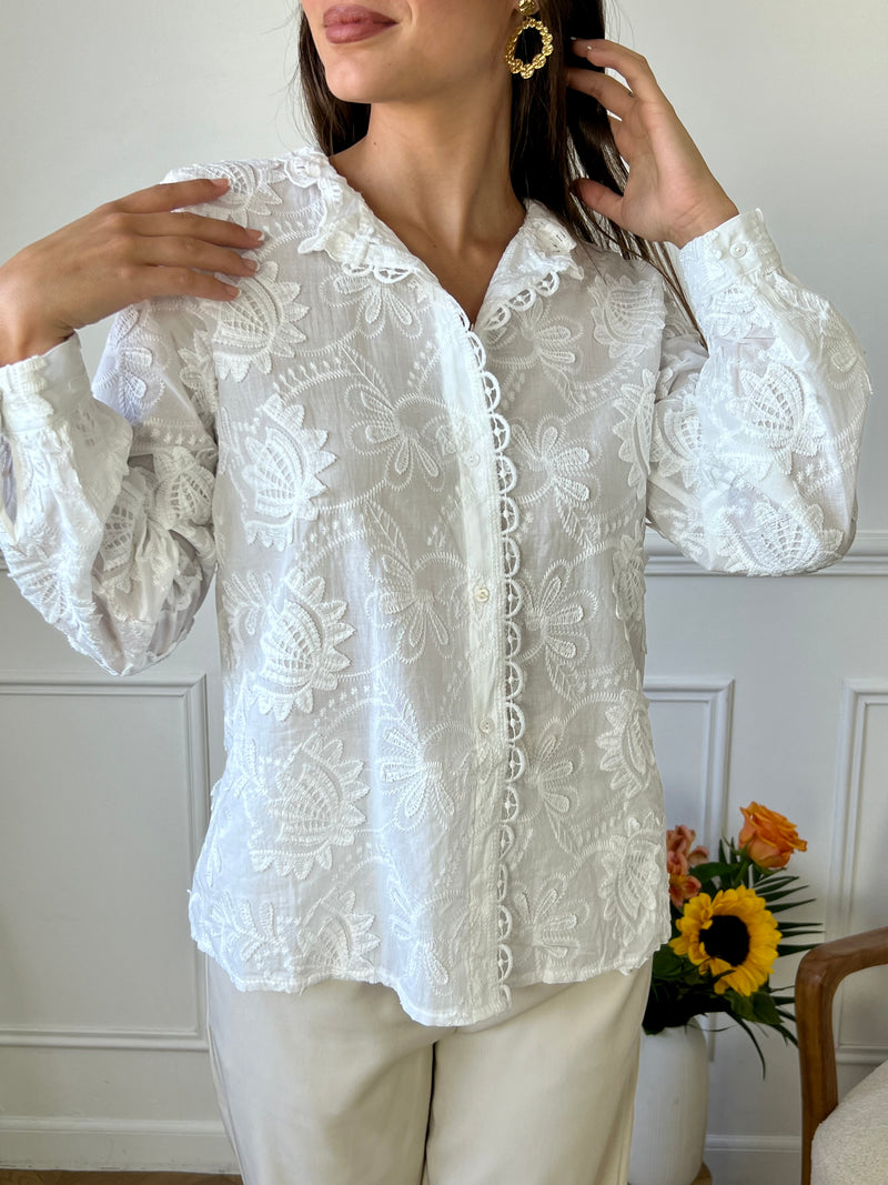 Cette chemise écrue élégante se distingue par ses délicates broderies et son col festonné, ajoutant une touche de raffinement et de féminité. Idéale pour un look chic et romantique, elle se prête parfaitement à des occasions spéciales ou à un style quotidien sophistiqué.