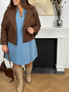 Cette robe courte en jean bleu clair séduit par sa coupe ample et son col V à revers. Dotée de manches longues, de poches pratiques et de détails dorés aux poignets, elle allie confort et style au quotidien.