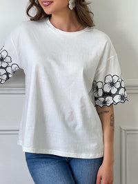 Découvrez notre magnifique Tee-shirt Adalia, avec son col rond et ses manches courtes confortables. Les motifs floraux sur les manches ajoutent une touche de féminité, tandis que le motif brodé ajouré apporte une élégance subtile. Fabriqué en coton, ce tee-shirt est à la fois doux et confortable. Profitez d'un style unique avec Adalia !