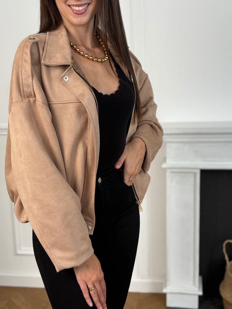 Cette veste courte style bombers se décline dans une teinte beige chaleureuse et tendance. Avec sa coupe moderne et son esprit casual-chic, elle apporte une touche de caractère à toutes vos tenues. Légère et polyvalente, elle se porte aussi bien au quotidien que pour compléter un look plus travaillé.