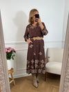 Robe longue marron élégante, mise en valeur par de délicats motifs brodés beiges qui lui apportent charme et raffinement.