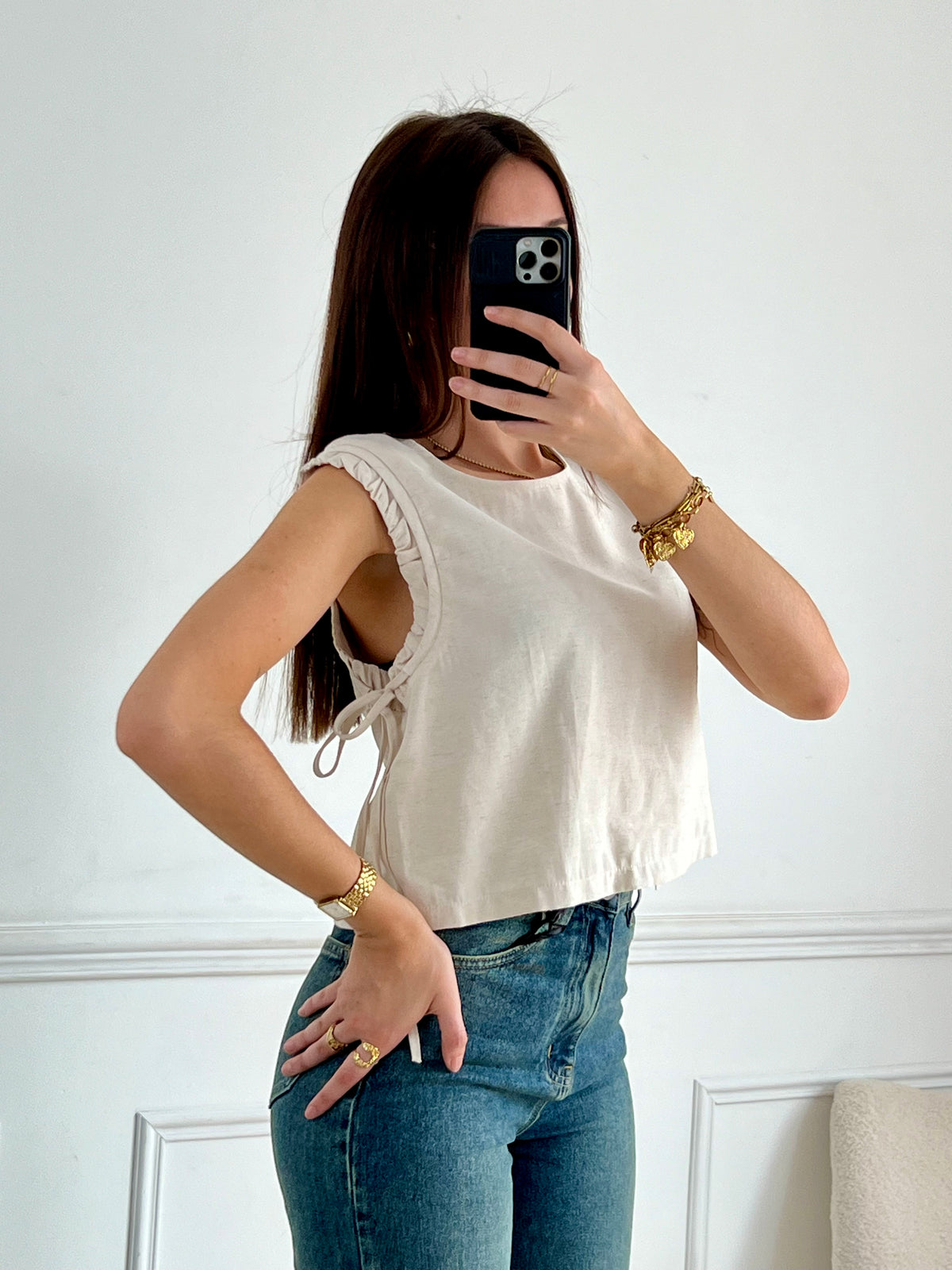 Ce top beige pour femme Tibo, sans manches avec volants, est idéal pour les jours ensoleillés. Les liens de serrage aux épaules ajoutent une touche de charme, tandis que les boutons au dos sur la longueur et le col rond offrent un look élégant et facile à porter.&nbsp;