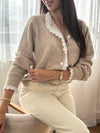 Délicat et élégant, ce pull taupe se distingue par ses détails en broderie écru, subtilement placés au col et le long de la patte de boutonnage. Une touche raffinée qui apporte charme et authenticité à cette pièce intemporelle.