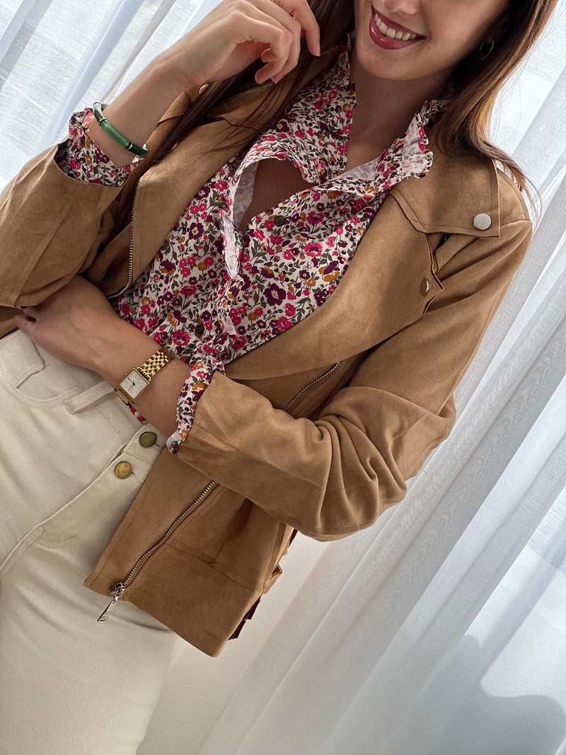 Cette chemise beige "Mia" avec motif floral offre une élégance délicate grâce à ses manches longues et ses volants raffinés au col, sur la longueur et aux manches.