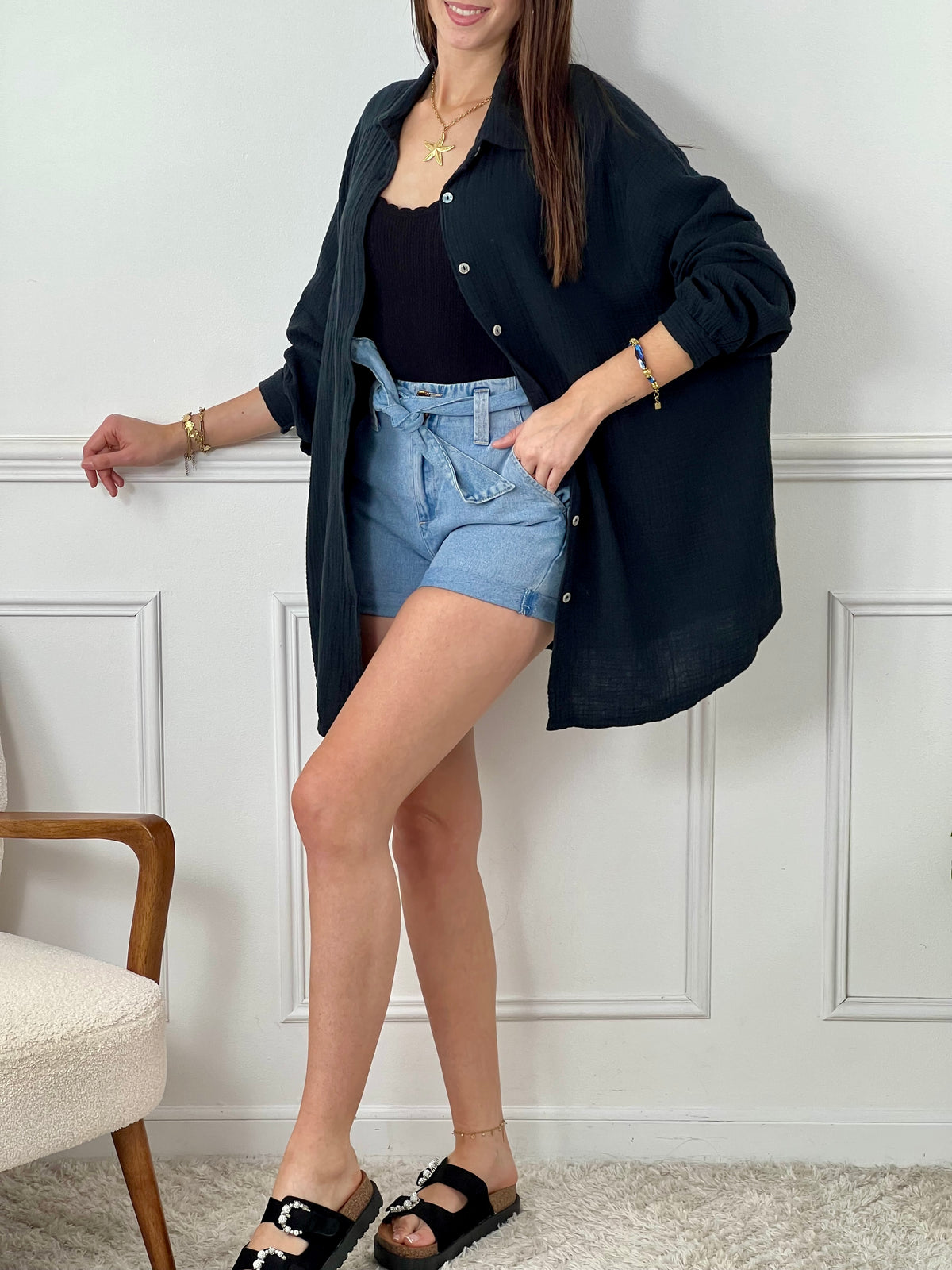 Optez pour la chemise Flore en gaze de coton noire, avec ses boutons sur la longueur et aux manches, son col chemise et son motif en sequin à l'arrière. Une touche d'originalité pour un look décontracté et tendance. Parfait pour toutes les occasions !