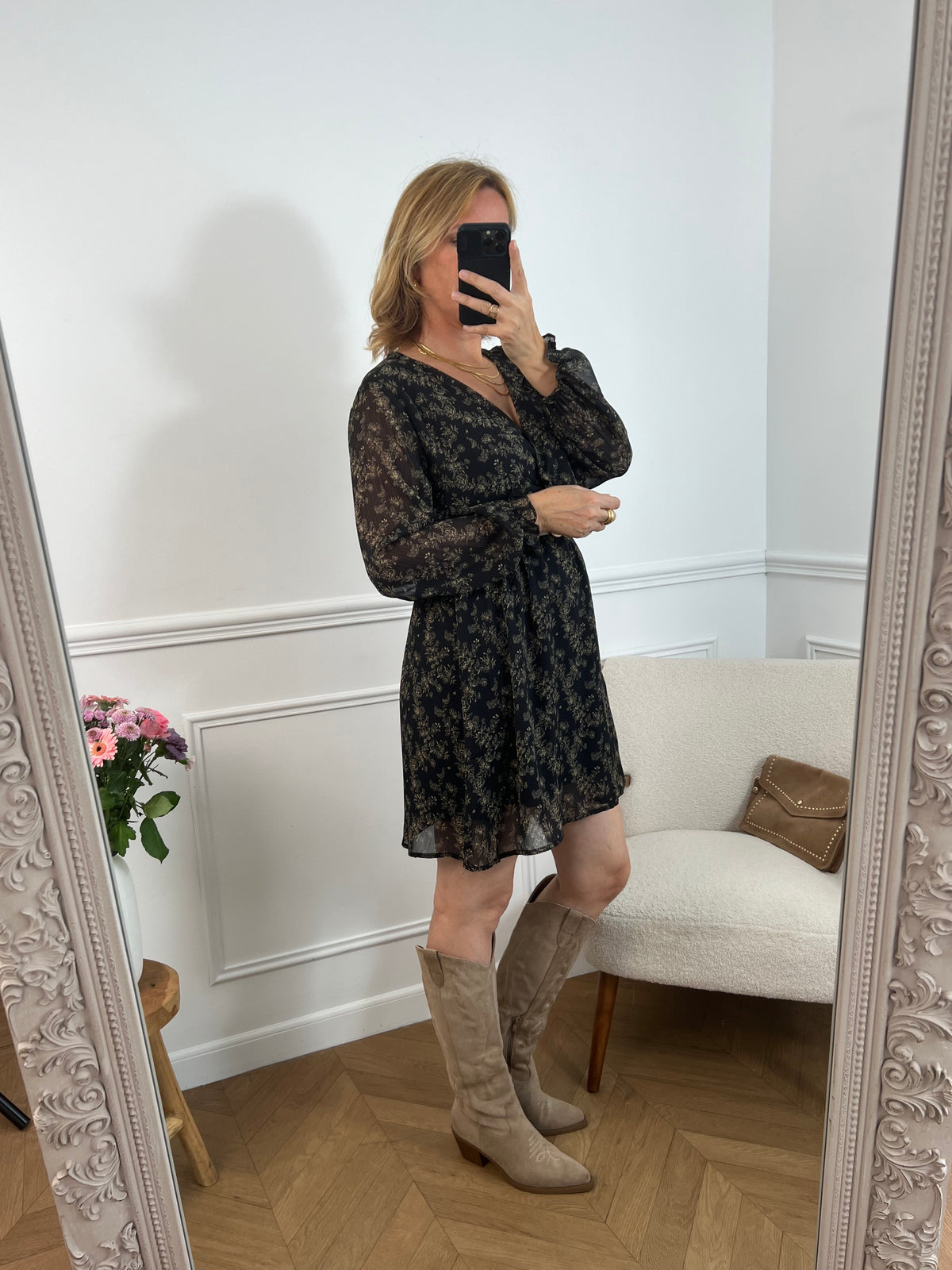 La robe courte Timy offre confort et élégance avec ses manches longues, son col cache-cœur et sa ceinture amovible. Ses motifs floraux en noir et beige donnent une touche élégante et féminine à cette pièce facile à porter au quotidien ou pour des occasions spéciales.