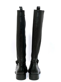 Ces bottes cavalières ont été créées pour accompagner les courbes avec élégance. Pensées spécialement pour les mollets larges, elles allient confort et style grâce à leur élastique d'ajustement et leur sangle raffinée à la cheville. Fabriquées au Portugal avec un cuir 100% de qualité, leur design bi-matière en noir intemporel est parfait pour un look chic et affirmé, tout en célébrant chaque silhouette avec soin.