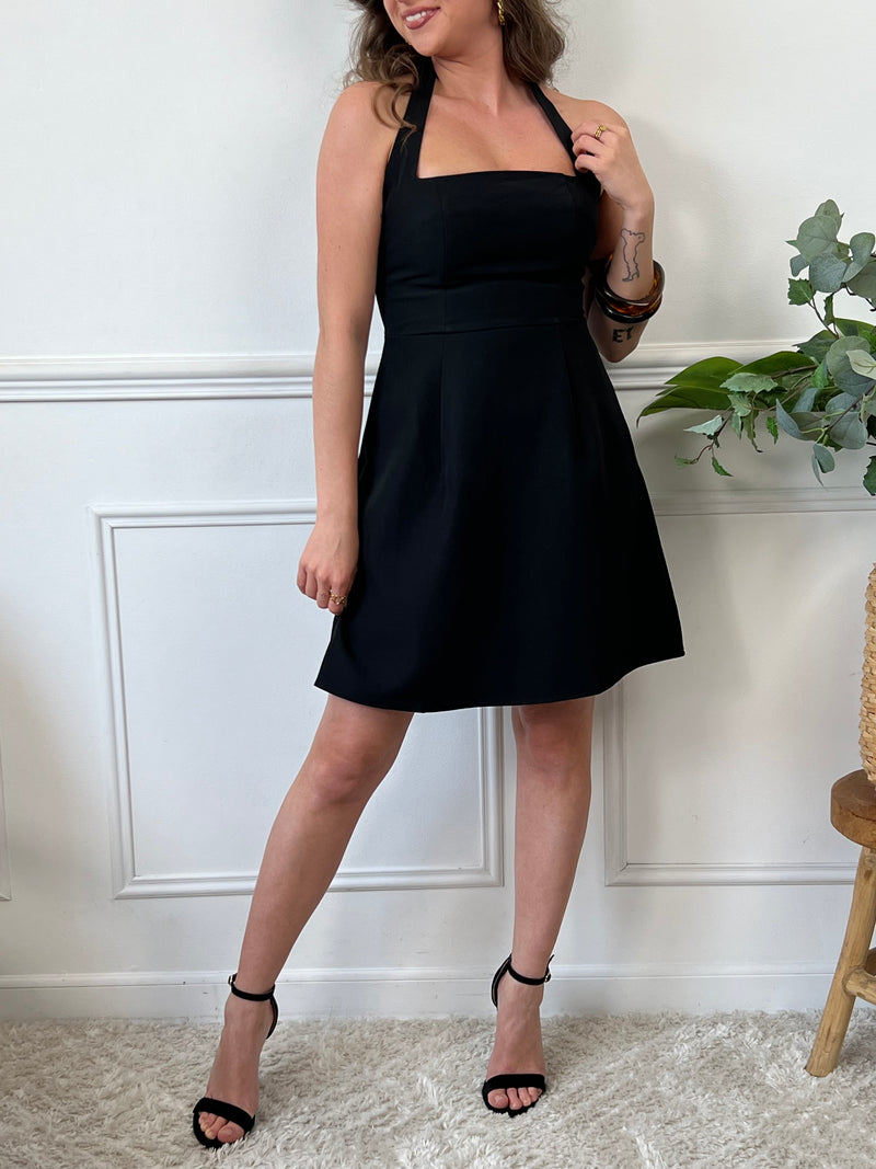 Courte et sans manches, elle met en valeur votre silhouette avec un col carré et un dos nu osé. La fermeture éclair au dos ajoute une touche de modernité. Osez en noir pour un look audacieux !