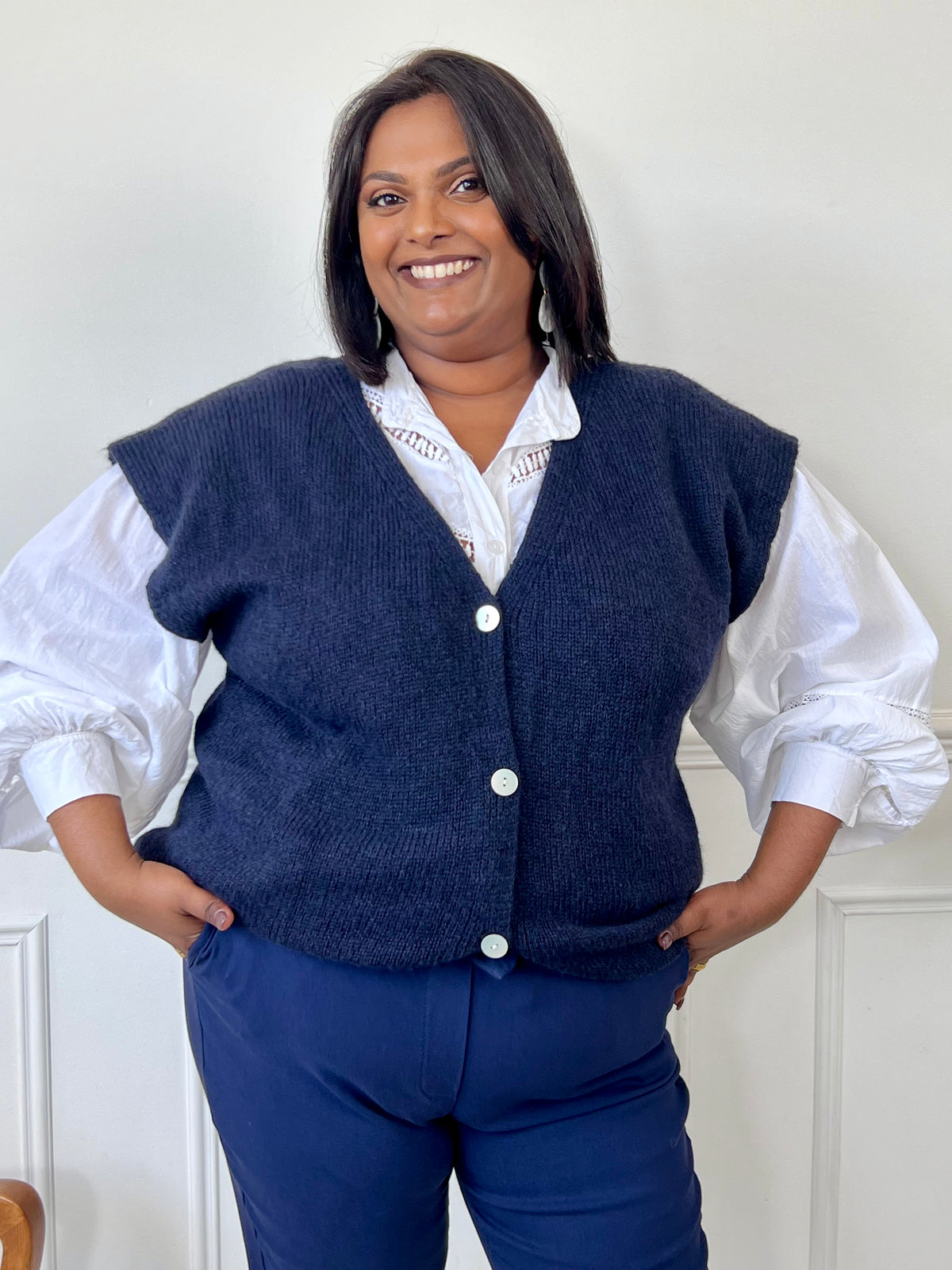 Ce gilet sans manches bleu marine est parfait pour les femmes en grande taille. Avec son col en V et sa coupe ample, il est à la fois confortable et élégant. Ses boutons sur la longueur ajoutent une touche de style, tandis que le bas resserré assure une silhouette flatteuse. Prêt pour des looks impressionnants !