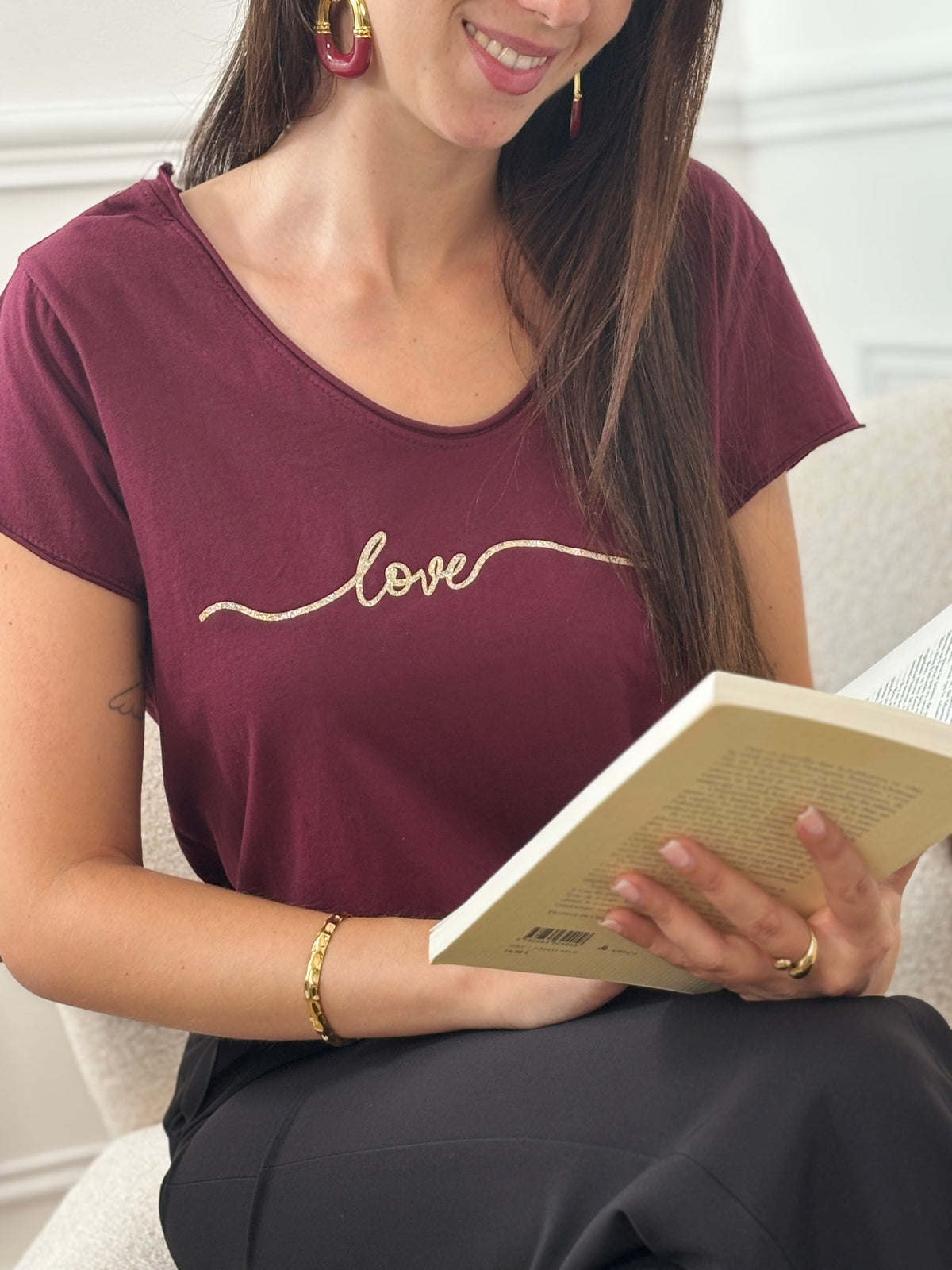 Ce tee-shirt bordeaux "Aliyah" allie confort et élégance avec ses manches courtes et son col rond classique. Sa touche distinctive, une inscription dorée sur le devant, apporte une subtile note de sophistication. Idéal pour un style décontracté mais soigné au quotidien.