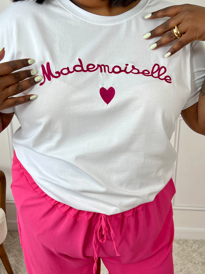 Tee-shirt mademoiselle écru et fuchsia pour femme. Ce tee-shirt à manches courtes séduit par son col rond classique et son inscription "Mademoiselle" accompagnée d’un petit cœur. Avec ses couleurs écru et turquoise, il apporte une touche fraîche et féminine à votre tenue du quotidien.