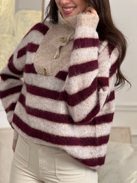 Chic et confortable, ce pull rayé bordeaux et beige séduit par son col montant modulable, rehaussé d'élégants boutons dorés. Une pièce douce et stylée, parfaite pour un look à la fois cosy et raffiné.