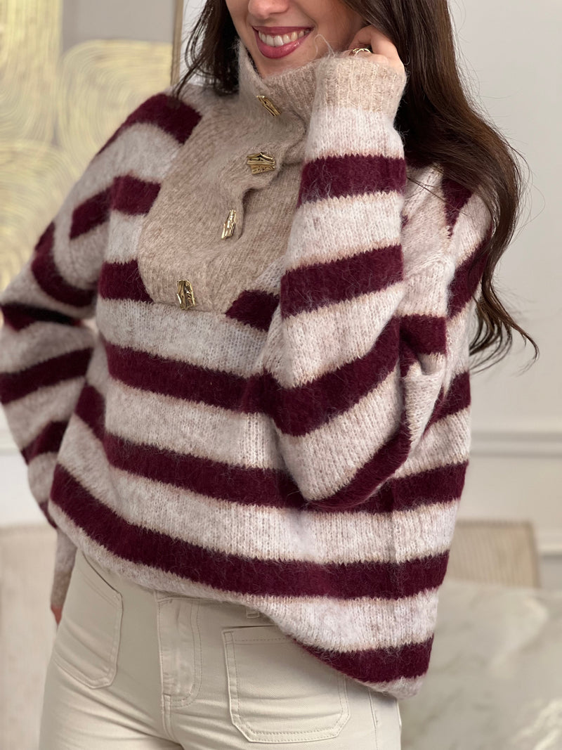 Chic et confortable, ce pull rayé bordeaux et beige séduit par son col montant modulable, rehaussé d'élégants boutons dorés. Une pièce douce et stylée, parfaite pour un look à la fois cosy et raffiné.