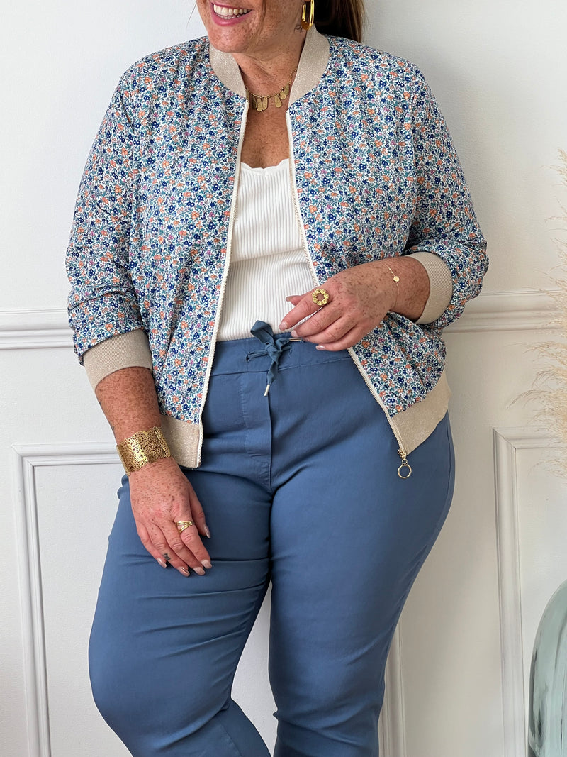 Optez pour un look floral avec la veste Resa ! Cette élégante bomber bleu à motifs fleurs et fil lurex argenté offre une coupe et légère, mais aussi une fermeture éclair dorée et des élastiques brillants au col, aux poignets et à la taille. Ajoutez une touche d'éclat à votre tenue avec ce motif coloré.