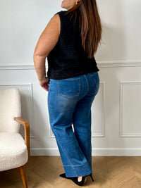 La veste moumoute sans manches Eda allie douceur et style. Conçue pour offrir un confort optimal, elle présente un col en V élégant et des broches dorées délicates sur le devant, qui ajoutent une touche sophistiquée.